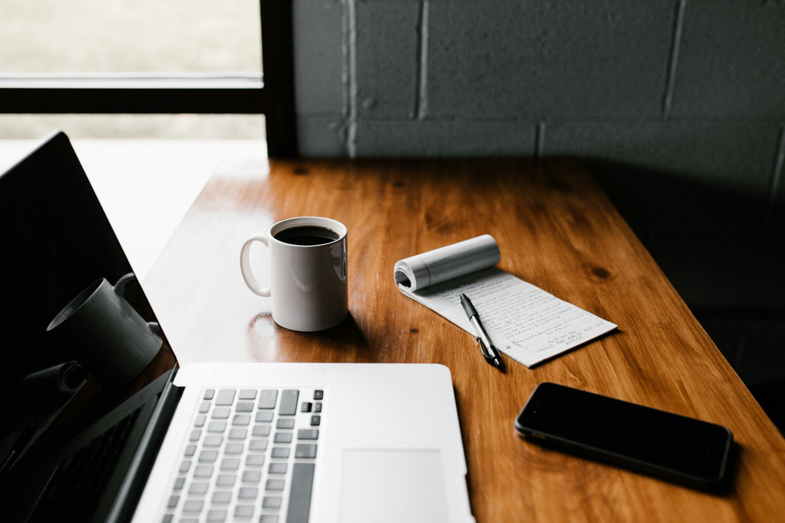10 Signs Your Job Is Quietly Firing You 4 MacBook Pro, white ceramic mug,and black smartphone on table