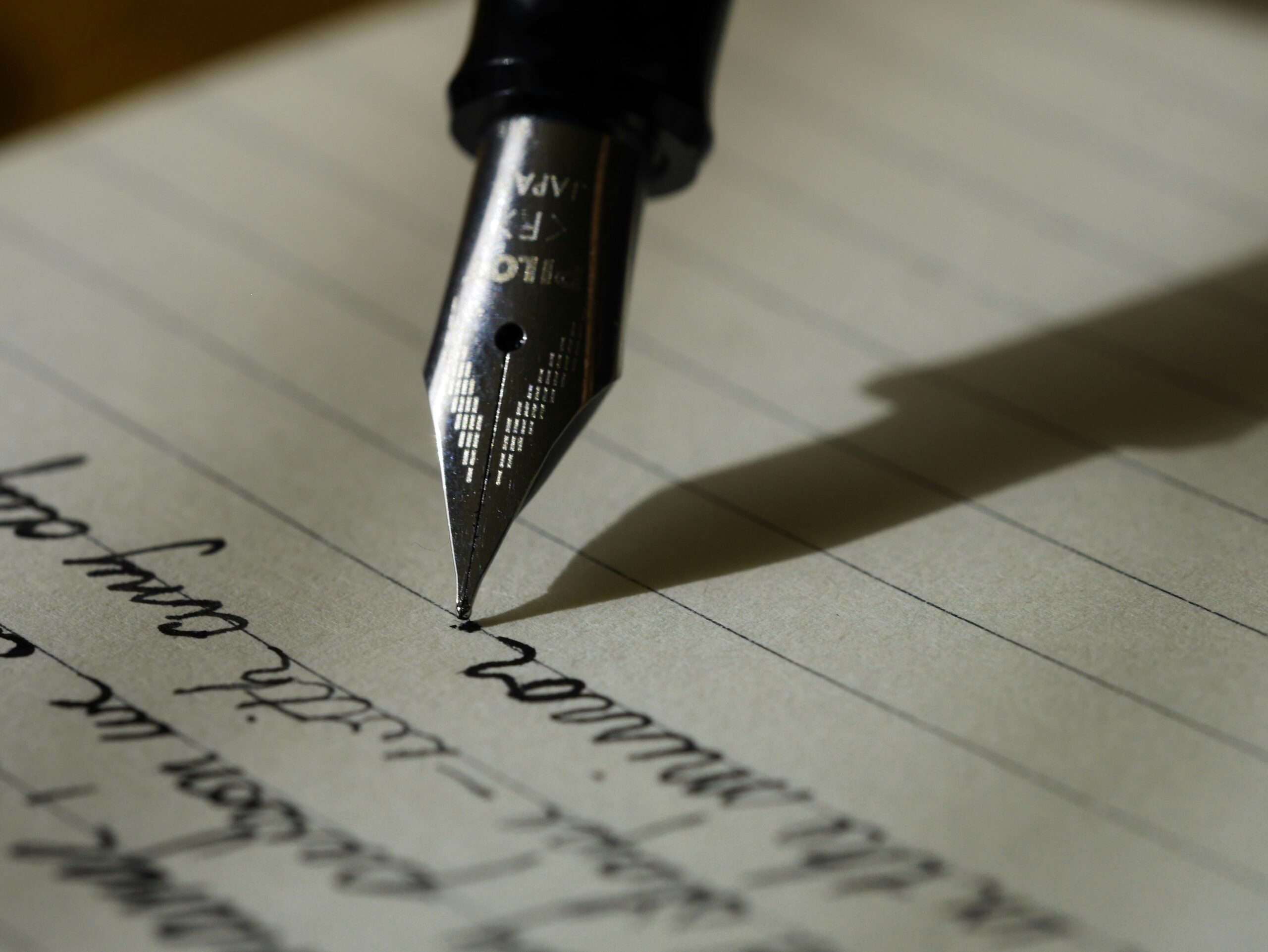 Embarking on Your Writing Journey: How to Build a Successful Career as a Writer 1 fountain pen on black lined paper